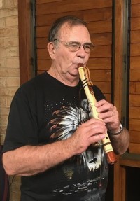 ray watchman playing native american-style flute at Coochimudlo Island resort restaurant.